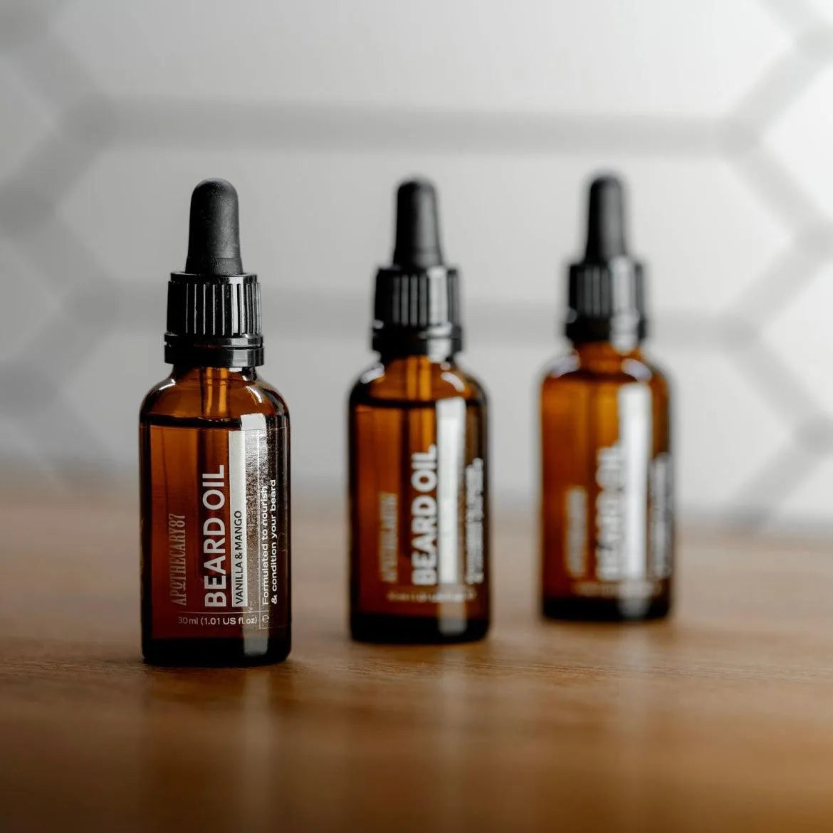 Apothecary 87 conditioning Beard Oil bottles in line. Fresh vanilla and mango fragrance