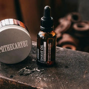 Apothecary 87 nourishing Shave Oil next to Apothecary 87 Shave Cream with sweet woody scent