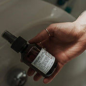 Apothecary 87 cleansing Hand Sanitiser bottle being held in hand