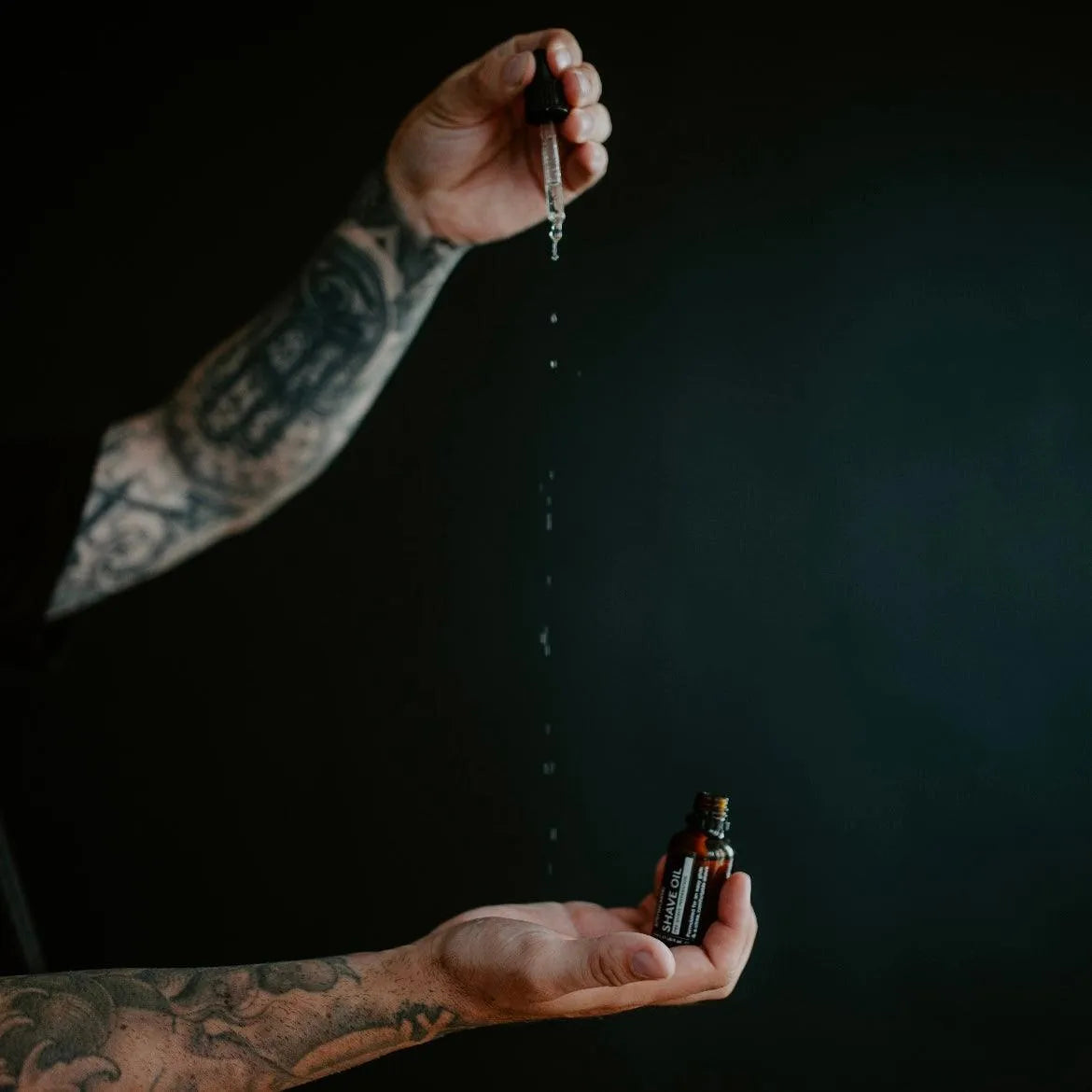 Apothecary 87 thick Shave Oil for wet shaving being dispensed from dropper
