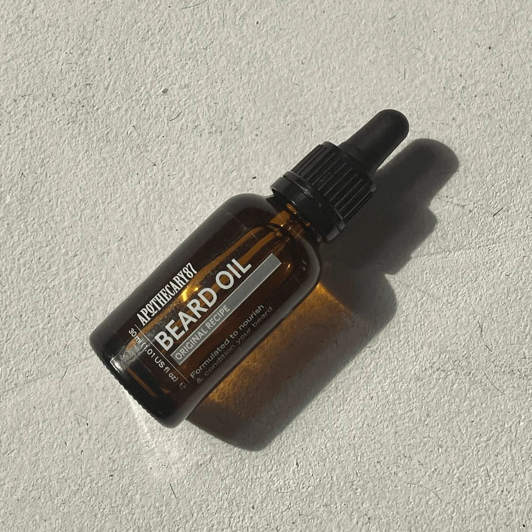 Apothecary 87 nourishing Beard Oil bottle on textured background