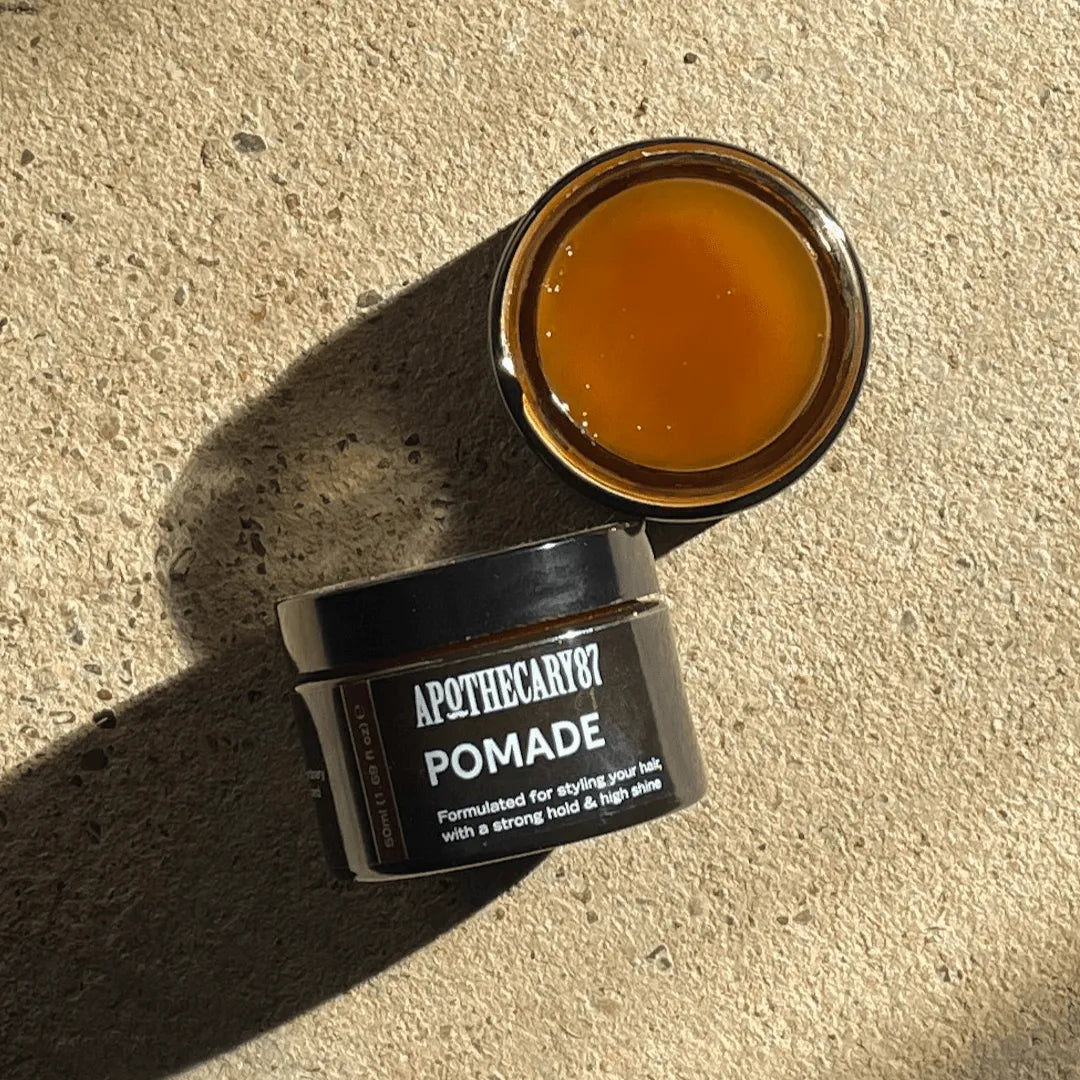 Apothecary 87 strong hold Pomade hair wax on textured background