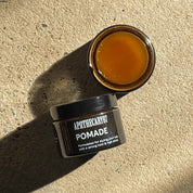 Apothecary 87 strong hold Pomade hair wax on textured background