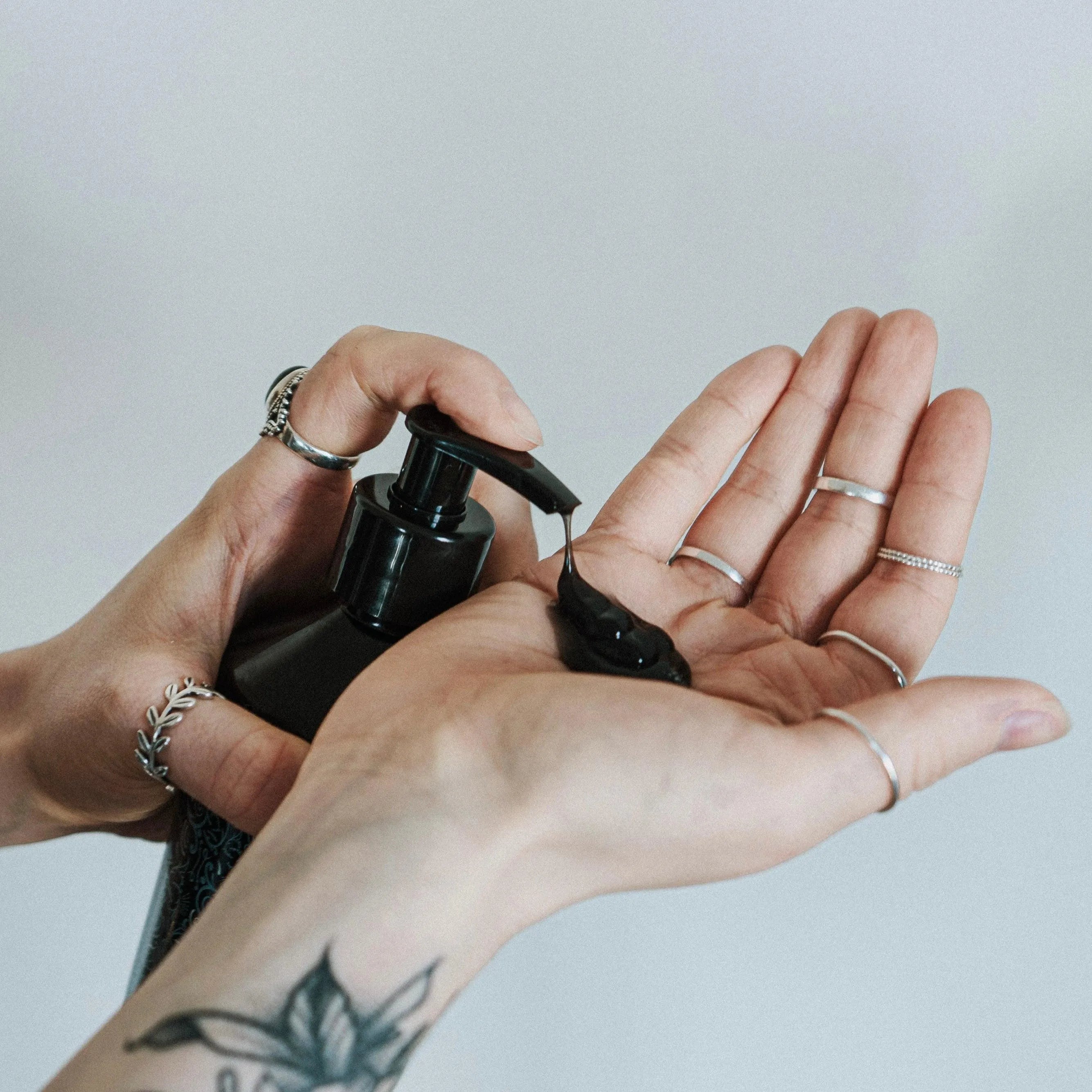 Apothecary 87 nourishing Botanical Shampoo with charcoal and fruit extracts in hand for washing hair